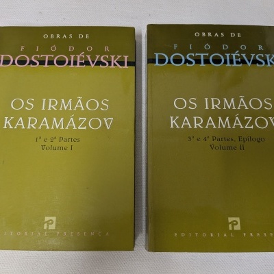 Dois livros verdes intitulados OS IRMÃOS KARAMÁZOV de Fiódor Dostoiévski sobre tecido branco