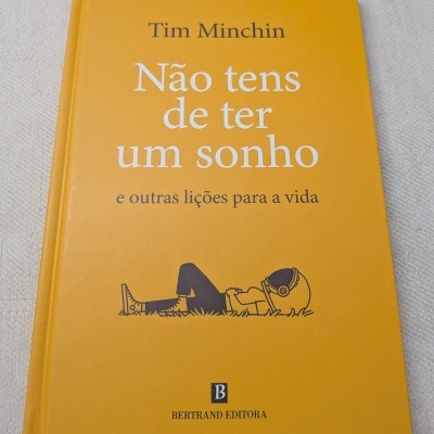 Livro amarelo Não tens de ter um sonho de Tim Minchin com ilustração e logo da editora