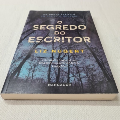 Capa de livro 'O Segredo do Escritor' de Liz Nugent com árvores no céu azul escuro