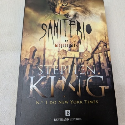 Capa do livro Samitério de animais de Stephen King com imagem de gato, cruzes e cenário de cemitério