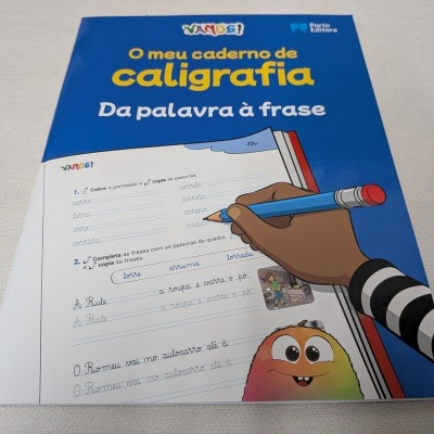 Caderno de caligrafia azul e branco com ilustração de mão a escrever e personagem sorridente