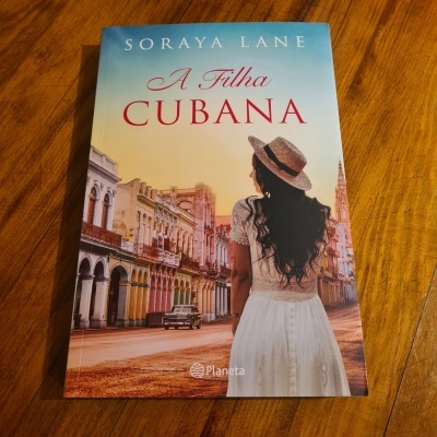 Capa do livro 'A Filha Cubana' com mulher de costas numa rua colorida