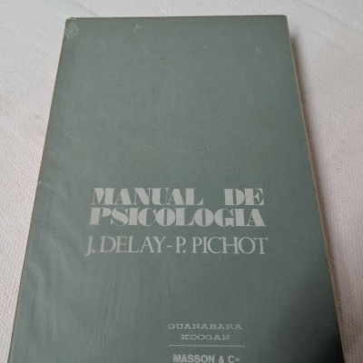 Capa de livro verde com título e autores em letras brancas sobre superfície branca.