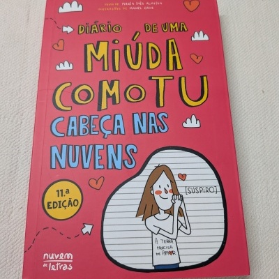 Capa de livro infantil vermelha com título e ilustrações de uma rapariga com expressão sonhadora.