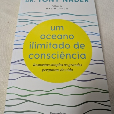 Capa branca de livro com ondas coloridas e círculo amarelo com texto azul e preto