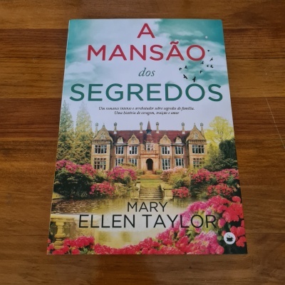 Capa do livro 'A Mansão dos Segredos' com imagem de mansão e flores