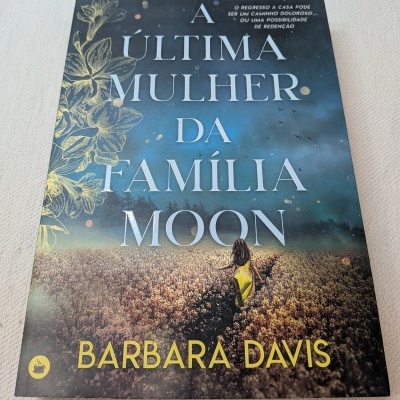 Capa de livro A Última Mulher da Família Moon com texto e imagem de mulher num campo.