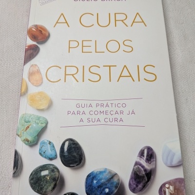 Capa de livro A Cura pelos Cristais com pedras coloridas