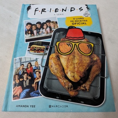 Capa de livro de receitas oficial da série FRIENDS com fotos e um frango assado desenhado.