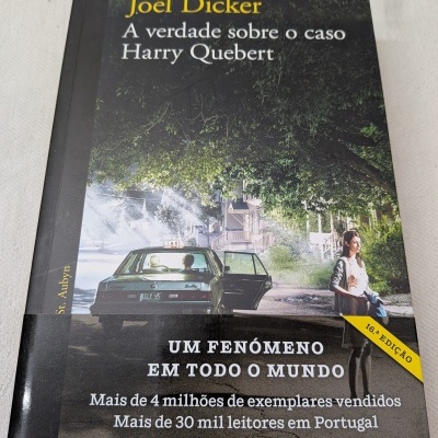 Capa do livro A verdade sobre o caso Harry Quebert de Joël Dicker com uma cena noturna e texto em português