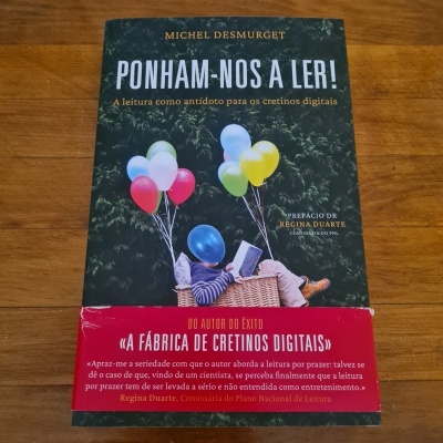 Capa do livro Ponham-nos a ler com criança, balões coloridos e faixa vermelha