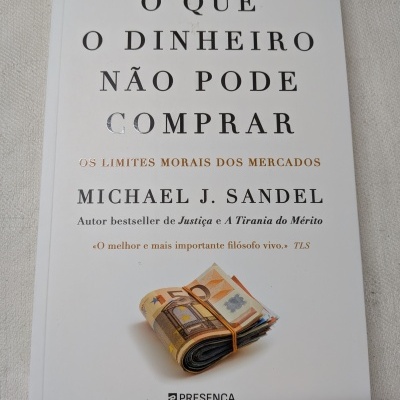Livro O QUE O DINHEIRO NÃO PODE COMPRAR de Michael J. Sandel com maço de notas de euro na capa
