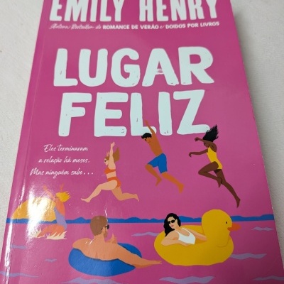 Capa de livro rosa com título LUGAR FELIZ e ilustração de pessoas numa piscina.