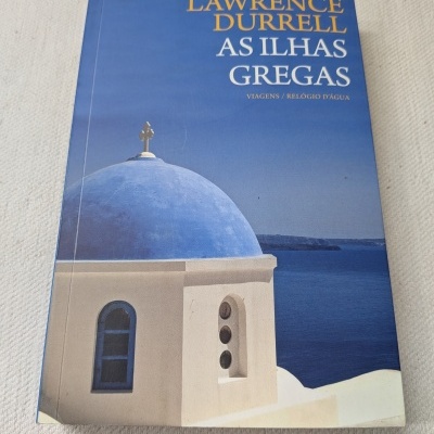 Capa de livro azul com título em amarelo e branco, cúpula azul e edifício branco com vista para o mar azul.