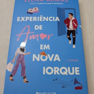 Capa de livro azul com título Experiência de Amor em Nova Iorque e ilustrações de casal e elementos vários
