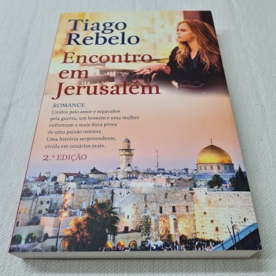 Capa do livro 'Encontro em Jerusalém' de Tiago Rebelo com imagem de Jerusalém e mulher loira