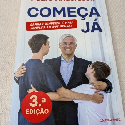Capa de livro com homem a sorrir e abraçar dois jovens, texto em azul e vermelho