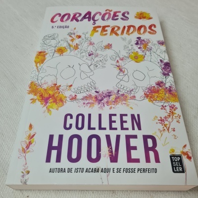 Capa de livro Corações Feridos com crânios e flores coloridas
