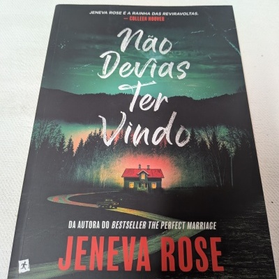 Capa do livro Não Devias Ter Vindo de Jeneva Rose com ilustração de casa iluminada na floresta à noite