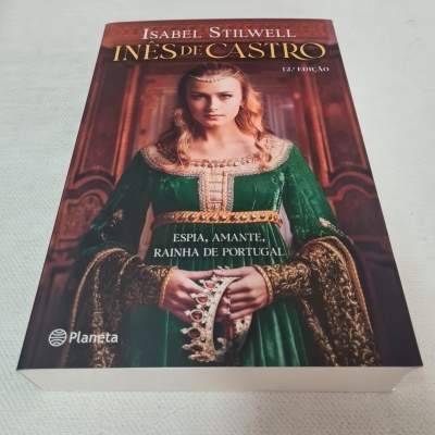 Capa do livro 'Inês de Castro' de Isabel Stilwell com imagem de mulher em vestido verde segurando uma coroa.
