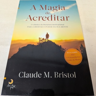 Capa do livro A Magia de Acreditar com imagem de pessoa e montanha ao pôr do sol