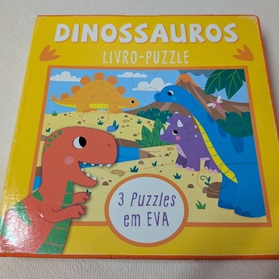 Livro-puzzle infantil amarelo com dinossauros ilustrados na capa