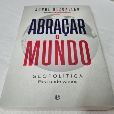 Capa de livro 'Abraçar o Mundo' com texto azul e vermelho em fundo branco