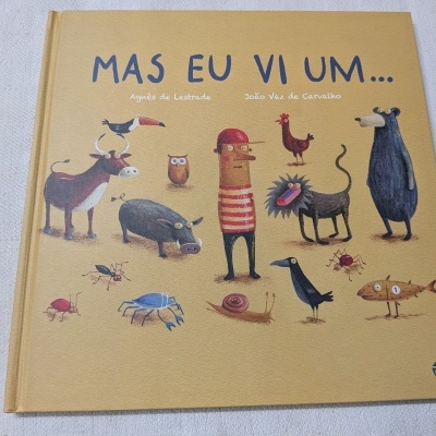 Capa de livro infantil bege com várias ilustrações de animais e texto MAS EU VI UM...
