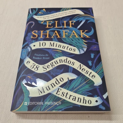 Livro '10 Minutos e 38 Segundos Neste Mundo Estranho' com capa azul e ilustrações florais