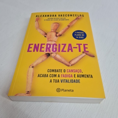 Livro amarelo 'ENERGIZA-TE' de Alexandra Vasconcelos sobre superfície branca.