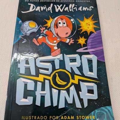 Capa de livro infantil Astro Chimp com macaco astronauta e planetas coloridos