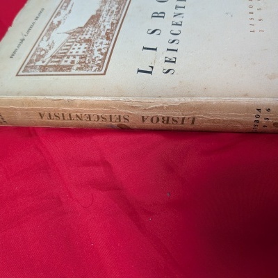 Capa de livro antigo Lisboa Seiscentista sobre tecido vermelho