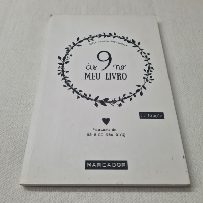 Livro branco com título Às 9 no Meu Livro e elementos gráficos de ramos em fundo branco texturizado.