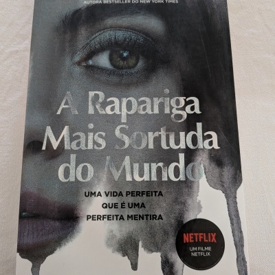 Capa de livro cinzenta com título e rosto feminino parcial e selo Netflix