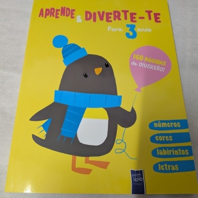 Livro infantil amarelo com desenho de pinguim e texto em português