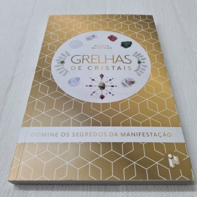 Livro Grelhas de Cristais com capa dourada e branca