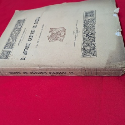 Livro antigo D. Antonio Caetano de Sousa sobre fundo vermelho