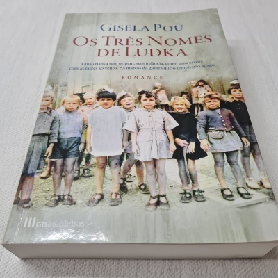 Capa do livro 'Os Três Nomes de Ludka' com crianças em fotografia antiga.