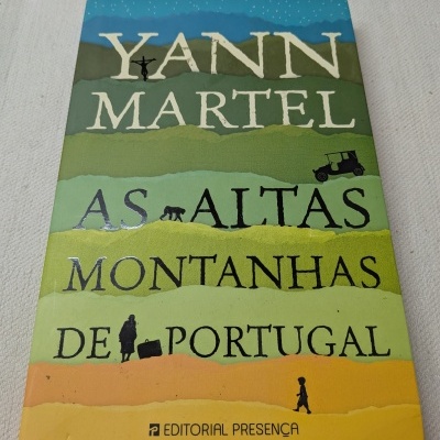 Capa de livro As Altas Montanhas de Portugal de Yann Martel com ilustrações e cores variadas.