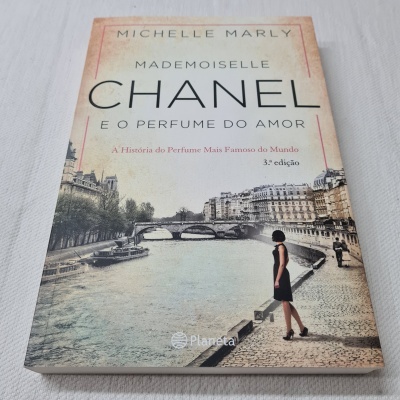 Capa de livro com mulher diante de rio urbano e título em letras grandes