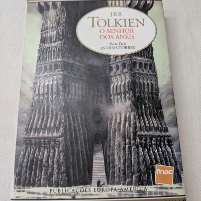 Livro O Senhor dos Anéis Parte Dois As Duas Torres de JRR Tolkien com imagem de torres e textos visíveis