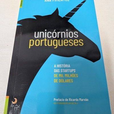 Capa de livro azul com ilustração de unicórnio preto e texto sobre startups portuguesas