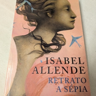Capa de livro Retrato a Sépia de Isabel Allende com ilustração de mulher perfil e pássaros azuis