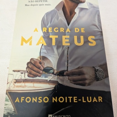 Capa de livro com homem de camisa branca segurando óculos e um barco ao fundo