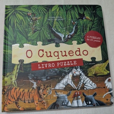 Livro puzzle infantil O Cuquedo com ilustração de animais e selva na capa.