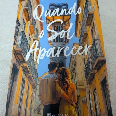 Capa do livro Quando o Sol Aparecer com casal numa rua entre edifícios amarelos e o Elevador de Santa Justa ao fundo