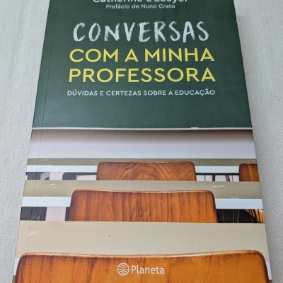 Capa de livro com título Conversas com a minha professora e cadeiras de madeira