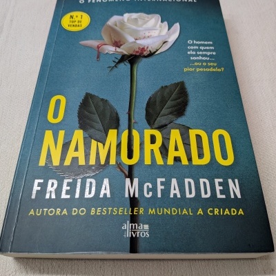 Livro O Namorado de Fréida McFadden com rosa branca manchada de sangue na capa