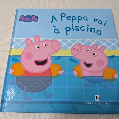 Capa do livro infantil A Peppa vai à piscina com personagens animados de porquinhos na piscina.
