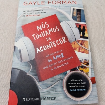 Capa livro Nós tínhamos de acontecer por Gayle Forman com auscultadores brancos e chávena de café